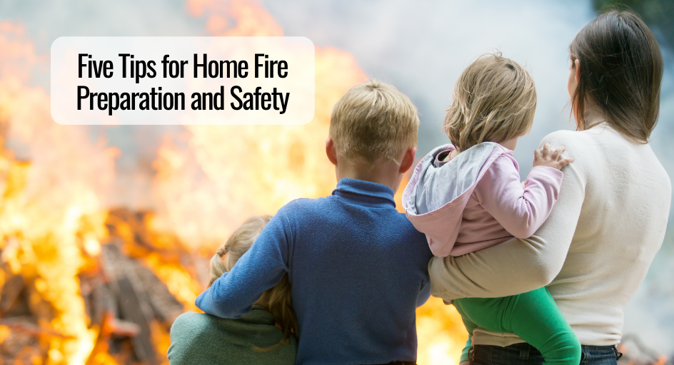 mother and her three children standing outside watching their home burn